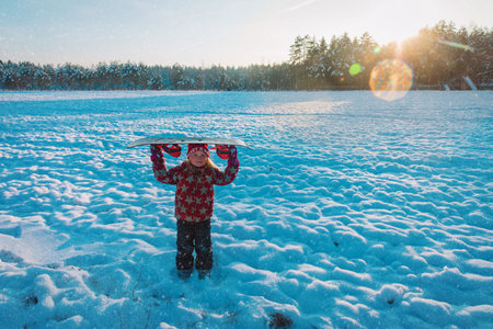 Snowboard winter sport. Cute girl with snowboard going to slide in winter natureの写真素材