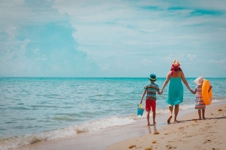happy family- mother with son and daughter-walk on beachの写真素材