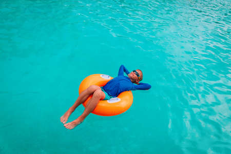 happy boy relax on floatie in poolの写真素材