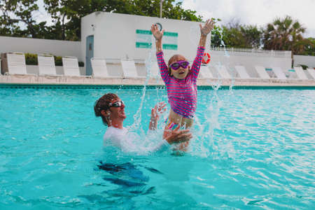 father and daughter have fun in swimming pool, family vacationの写真素材