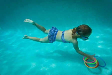little girl swimming underwater, kid learning to diveの写真素材