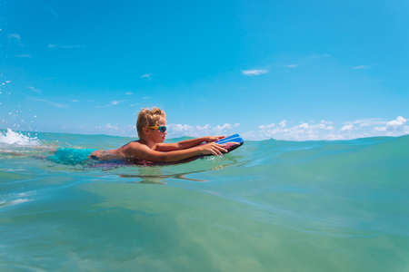 happy kid on the surfboard at sea, family vacationの写真素材