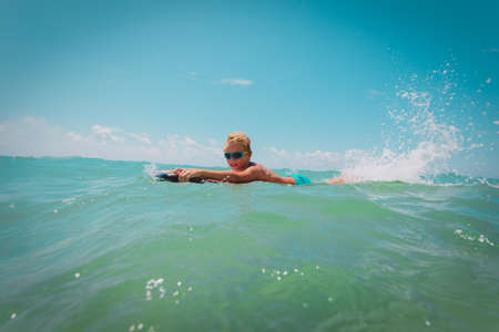 happy kid on the surfboard at sea, family vacationの写真素材