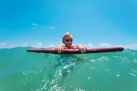 happy kid on the surfboard at sea, family vacationの写真素材