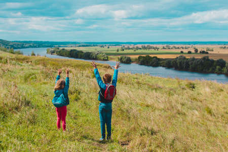 happy kids travel in nature, boy and girl enjoy scenic viewの写真素材