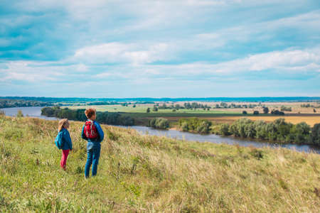 kids travel in nature, boy and girl enjoy scenic viewの写真素材