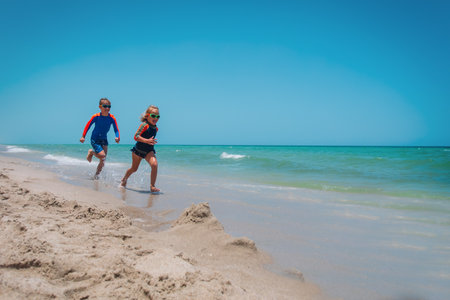 kids run, boy and girl have fun on tropical beachの写真素材