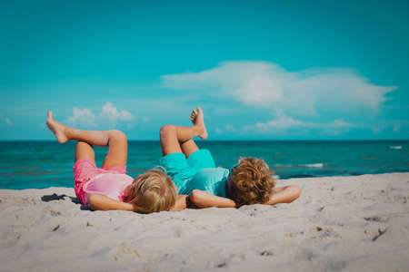 happy boy nd girl relax on tropical beachの写真素材
