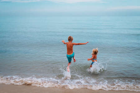 happy boy and girl run swim on beachの写真素材