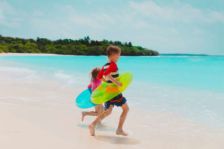 happy kids- boy and girl- go swim on beachの写真素材