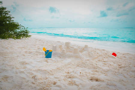 kids toys and sandcastle on tropical beach