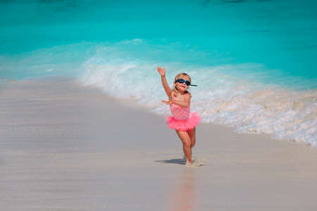 happy little girl play with water on beach, family vacationの写真素材