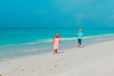 happy boy and girl running on beachの写真素材