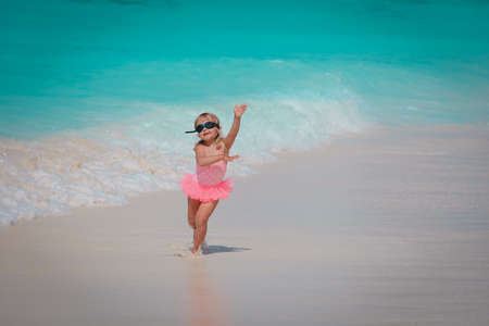 happy little girl play with water on beach, family vacationの写真素材