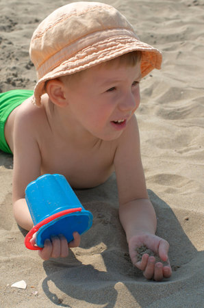 little boy in panama playing with sandの写真素材