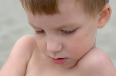 sad little boy on a sand beachの写真素材