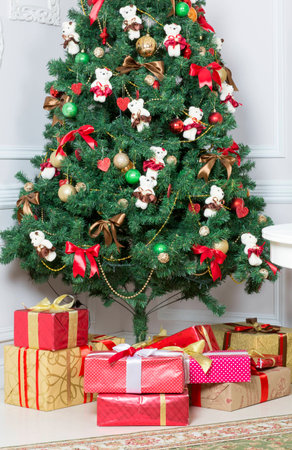 Christmas tree decorated with toys. Gifts lie under the tree.の写真素材