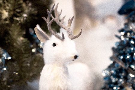 Toy deer. Christmas decoration, deer in the snow among the trees.の写真素材