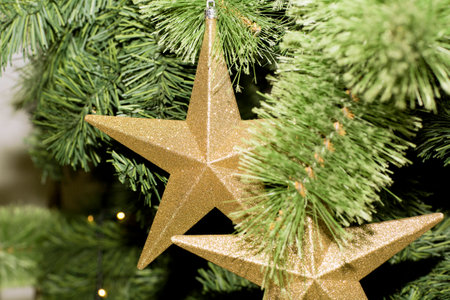 Christmas tree decorated with toys. Yellow star hanging on a branch of a Christmas tree.の写真素材