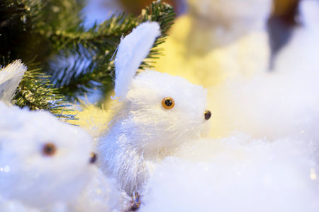 Toy rabbit. Christmas decoration, rabbit in the snow among the trees.の写真素材
