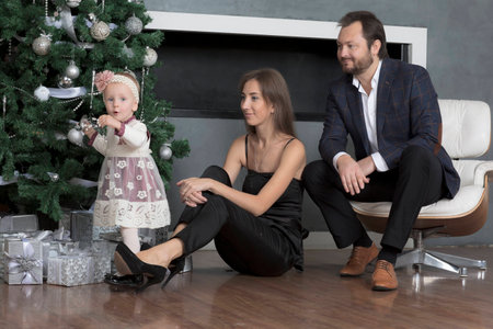 Family portrait near the Christmas tree. Christmas family portrait near the fireplace.の写真素材