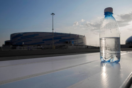 Bottle of water at sunset. The bottle stands on the white bench.の写真素材