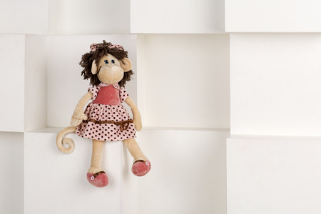 Soft toy monkey on a white background. A child's toy against a white wall.の写真素材