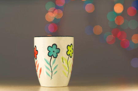 Tea mug on the background bokeh. Ceramic mug stands on the table.
