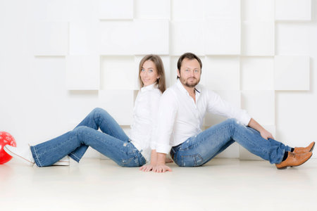 Portrait of a man and woman. Portrait of husband and wife in shirts against a white wall.の写真素材
