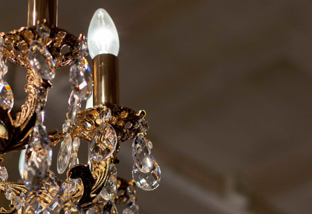 Brass chandelier with crystal. Lighted chandelier with crystal pendants.
