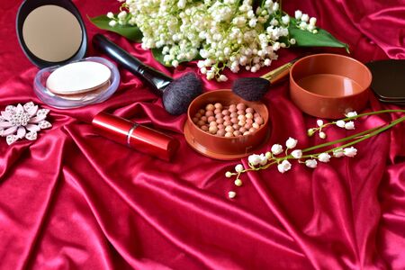 Set of decorative cosmetics on a background of red silk.の写真素材