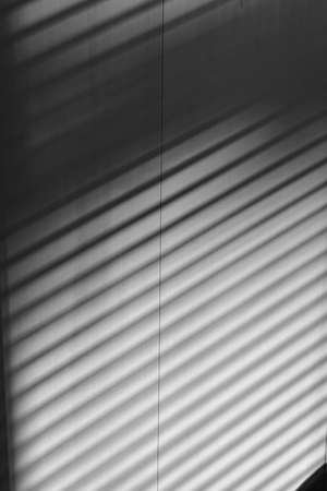 Shadow from blinds on the wall in the room.の写真素材