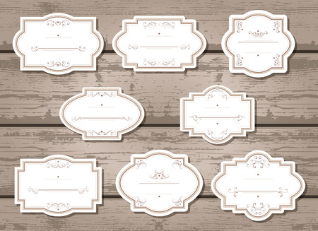 set of labels and tags with frames and decorative elements. On wooden background.のイラスト素材