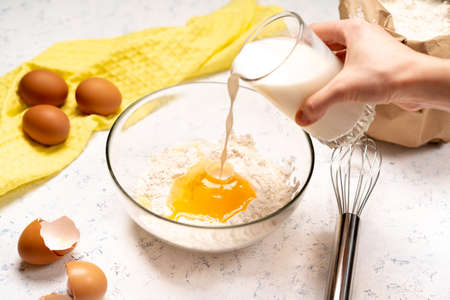 the process of making dough for pancakes with ingredients on a light table, eggs and flour are...