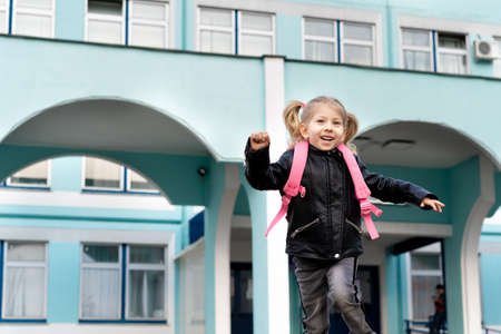 Happy little blonde girl flees school, concept of training preschoolers.