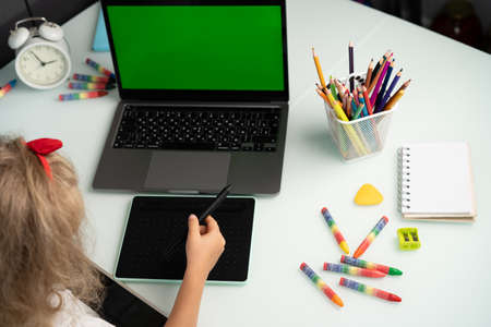 little girl with graphics tablet and laptop, modern schoolchildren, graphic design courses for childrenの写真素材