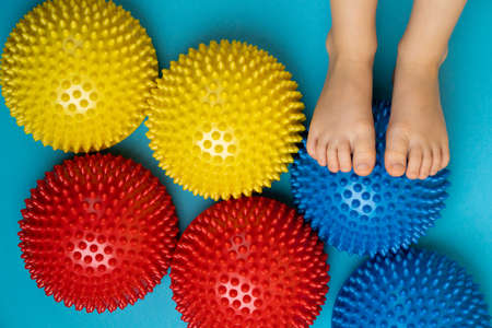childrens feet with a colored balancer on a light blue background, treatment and prevention of flat feet, valgus deformity of the footの写真素材