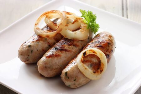 Succulent griddled sausages with onion  Shallow depth of fieldの写真素材