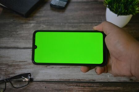smartphone In the hands of a man . with green screen for key chroma screen.の写真素材