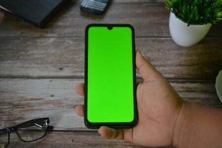 Self Perspective smartphone In the hands of a man with green screen for key chroma screen.の写真素材