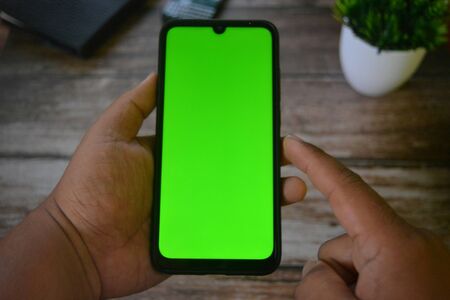 Self Perspective smartphone In the hands of a man with green screen for key chroma screen.の写真素材