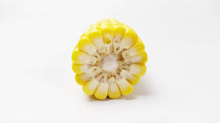 Close up fresh yellow sweet corn on cutting board isolated on white backgroundの写真素材