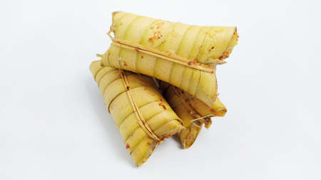 Lepet or leupeut Indonesian traditional food with glutinous rive and grated coconut ingredients wrapped in coconut leaves isolated on white backgroundの写真素材