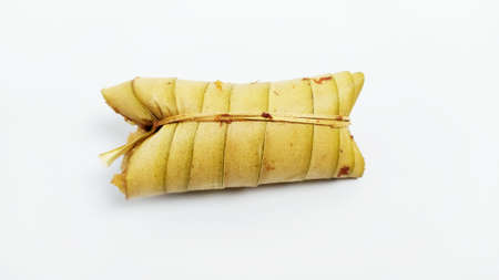 Lepet or leupeut Indonesian traditional food with glutinous rive and grated coconut ingredients wrapped in coconut leaves isolated on white backgroundの写真素材