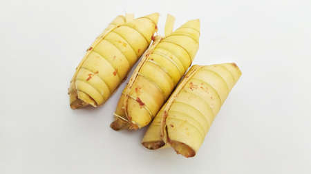 Lepet or leupeut Indonesian traditional food with glutinous rive and grated coconut ingredients wrapped in coconut leaves isolated on white backgroundの写真素材