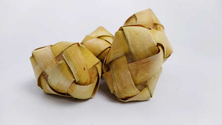 Kupat or ketupat Indonesian traditional food with rice ingredients wrapped with palm leaves isolated on white backgroundの写真素材