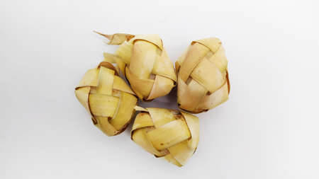 Kupat or ketupat Indonesian traditional food with rice ingredients wrapped with palm leaves isolated on white backgroundの写真素材