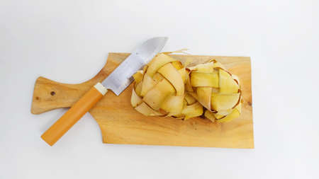 Kupat or ketupat Indonesian traditional food with rice ingredients wrapped with palm leaves isolated on white backgroundの写真素材