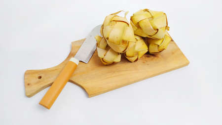 Kupat or ketupat Indonesian traditional food with rice ingredients wrapped with palm leaves isolated on white backgroundの写真素材
