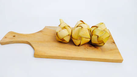 Kupat or ketupat Indonesian traditional food with rice ingredients wrapped with palm leaves isolated on white backgroundの写真素材
